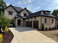 Stunning brick home featuring a three car garage and beautifully landscaped front yard at 724 Ideal Way, Charlotte, NC 28203