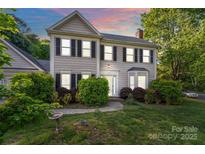 Charming two-story home featuring a well-manicured lawn and classic architectural details at 9100 Cameron Wood Dr, Charlotte, NC 28210