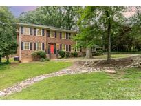Charming brick two-story home with manicured lawn and a red front door at 1000 Rudd Rd, Gastonia, NC 28054