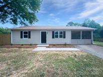 Charming single-story home featuring neutral siding, black door, and refreshed landscaping at 109 Downing St, Troutman, NC 28166
