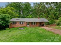 Cozy brick ranch-style home with lush greenery and a covered carport at 302 Kimberlee Dr, Shelby, NC 28152