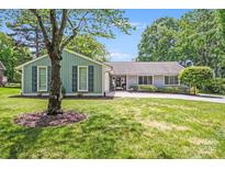 Charming ranch-style home with mature landscaping and a circular driveway on a sunny day at 3619 Chilham Pl, Charlotte, NC 28226