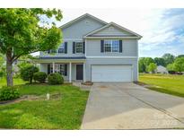 Two-story home featuring a two-car garage, front porch, and lush green lawn at 5219 Biederbeck Dr, Charlotte, NC 28212