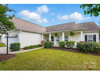 Charming one-story home with well-manicured lawn, inviting front porch and neutral siding at 8726 Castle Cliff Dr, Matthews, NC 28105