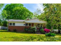 Charming brick home featuring a well-manicured lawn and colorful, mature landscaping at 105 Hopper St, Clover, SC 29710