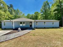 Charming home featuring a stone walkway, manicured lawn and light blue siding at 109 Bee Tree Ln, Salisbury, NC 28144