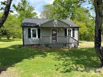 Charming home with a covered front porch, black shutters and a well-maintained lawn at 155 Ervin Loop, China Grove, NC 28023