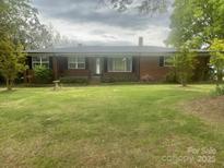 Charming one-story brick home featuring a well-manicured front lawn and mature trees at 1620 Moss Springs Rd, Albemarle, NC 28001