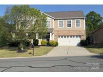 Traditional two-story home with a brick facade and well-manicured front lawn at 1905 Yellow Daisy Dr, Matthews, NC 28104
