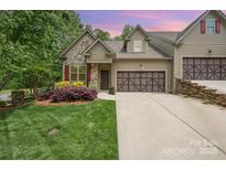 Charming home featuring stone accents, a two-car garage, a well-manicured lawn and beautiful landscaping at 3004 Village Ridge Dr, Gastonia, NC 28056