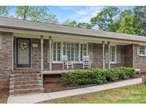 Charming brick home with a covered front porch and rocking chairs at 3378 Tanglewood Dr, Rock Hill, SC 29732