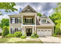 Charming two-story home features a welcoming front porch, attached two-car garage, and well-manicured landscaping at 349 Miners Cove Way, Fort Mill, SC 29708