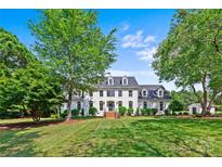 Expansive front yard view of a white brick two-story home with mature trees at 426 Walden Trl, Waxhaw, NC 28173