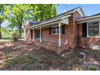Charming brick home featuring a covered front porch with white columns and ample space at 4734 Polk Ford Rd, Stanfield, NC 28163