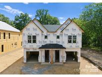 Exterior view of a new construction duplex featuring Tyvek wrap, a covered entrance, and attached garages at 511 Bowman Rd, Charlotte, NC 28217