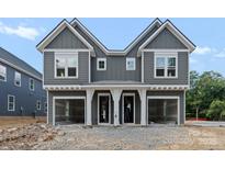 New construction townhome showcases a gray exterior, white trim, and a two-car garage at 511 Bowman Rd, Charlotte, NC 28217