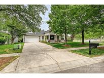 Charming home with well-manicured lawn, inviting front porch, and a spacious driveway leading to a two-car garage at 1000 Millbank Dr, Matthews, NC 28104