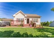 Charming single-story home with a cozy front porch and well-maintained lawn, perfect for relaxing outdoors at 1556 Berkshire Dr, Newton, NC 28658