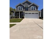 Charming two-story home with a well-maintained lawn and a two-car garage at 1933 Tin Roof Ln, Monroe, NC 28112