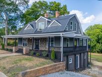Charming two-story home with a inviting covered front porch, brick accents, and landscaped yard at 217 S Green St, Wadesboro, NC 28170