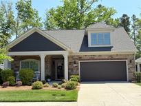 Charming brick and siding home featuring a covered front porch and attached two-car garage at 2306 Wesley Landing Rd, Waxhaw, NC 28173
