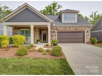 Charming home showcasing stone accents, a covered porch, and a well-manicured front yard at 2306 Wesley Landing Rd, Waxhaw, NC 28173