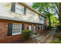 Traditional brick townhouse with black shutters, and landscaped entrance at 2332 Kenmore Ave, Charlotte, NC 28204