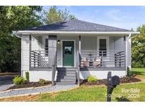 Charming home featuring a covered front porch and a beautifully landscaped yard at 403 Broad St, Kannapolis, NC 28081