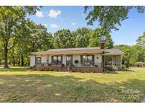 Charming one-story home with a welcoming front porch and well-maintained lawn surrounded by mature trees at 5317 Friendly Baptist Ch Rd, Indian Trail, NC 28079