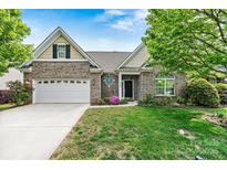 Charming brick home with manicured lawn, two-car garage, and beautiful landscaping at 5722 Kirkwynd Commons Dr, Charlotte, NC 28278