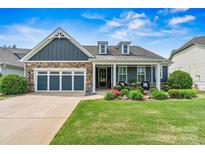 Charming home featuring a stone facade, a welcoming porch, and a well-manicured front yard at 7549 Short Putt Ct, Charlotte, NC 28215