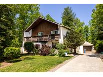Charming two-story home with a wood deck, detached garage, and well-maintained landscaped yard at 85 Riley Dr, Taylorsville, NC 28681