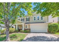 Charming two-story home with a two-car garage, lush landscaping, and a welcoming front porch at 8919 Oransay Way, Charlotte, NC 28278