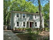 Charming two-story home with light green siding, white shutters, mature trees and a well-maintained front yard at 8936 Rittenhouse Cir, Charlotte, NC 28270