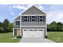 Charming two-story home features a classic design with gray siding and a large garage door at 120 Elm Forest Ln, China Grove, NC 28023