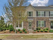 Charming townhouse featuring a stone facade, manicured landscaping, and a welcoming entrance at 12641 Glowing Peak Rd, Huntersville, NC 28078