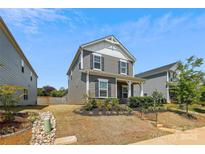 Charming two-story home featuring gray siding, white trim, and a well-manicured front yard with lovely landscaping at 13210 Kenworth Rd, Charlotte, NC 28278