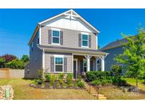 Charming two-story home with gray siding, black shutters, and a well-manicured front yard at 13210 Kenworth Rd, Charlotte, NC 28278