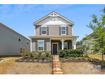 Charming two-story home featuring a welcoming front porch and landscaped front yard at 13210 Kenworth Rd, Charlotte, NC 28278