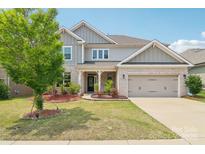 Charming two-story home with brick and gray siding, a well-manicured lawn, and an attached two-car garage at 15108 Autumn Sage Dr, Charlotte, NC 28278