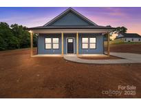 Charming single-story home featuring a covered porch with sturdy wooden columns and a modern blue exterior at 15700 Stokes Ferry Rd, Richfield, NC 28137