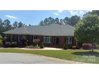 Charming brick home featuring manicured landscaping, a well-kept lawn, and classic architectural details at 216 Commodore Ct, Belmont, NC 28012