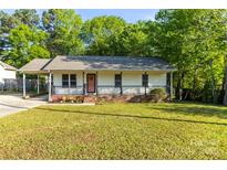 Charming single-story home with covered porch, front yard, and carport, offering a cozy curb appeal at 304 W Fourth St, Cherryville, NC 28021