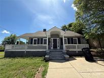 Charming gray home with a covered porch, black shutters and a quaint, inviting front yard at 406 S Catawba St, Lancaster, SC 29720