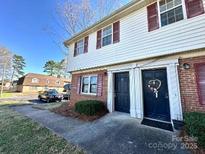 Two-story townhouse with brick and siding, featuring dual front doors and well-maintained landscaping at 5812 Hunting Ridge Ln # A, Charlotte, NC 28212
