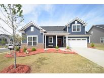 Charming two-story home with manicured lawn and inviting front porch at 705 Hinterland Ln, Matthews, NC 28104