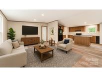 Bright living room featuring a cozy seating area, TV, and seamless flow into the kitchen at 850 Deep Hollow Ct, Clover, SC 29710