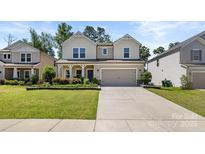 Charming two-story home with a manicured lawn and a two-car garage at 9849 Steele Meadow Rd, Charlotte, NC 28273