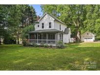 Charming two-story home with a screened-in porch and mature trees at 105 Horsestable Ct, Mooresville, NC 28115