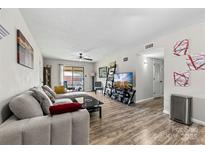 Comfortable living room featuring a neutral sectional sofa and wood-look flooring, brightened by natural light at 123 Carriage House Dr, Kannapolis, NC 28081